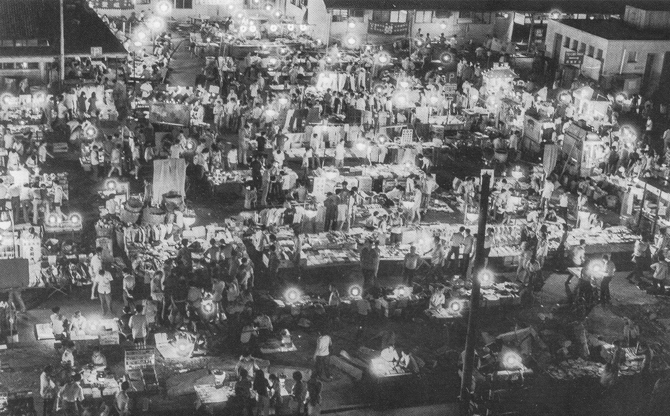 約1970年於上環新填地開設的各類攤子，即著名的「平民夜總會」。1970年代中，這裏興建了新港澳碼頭及信德中心。（圖片來源：鄭寶鴻提供）