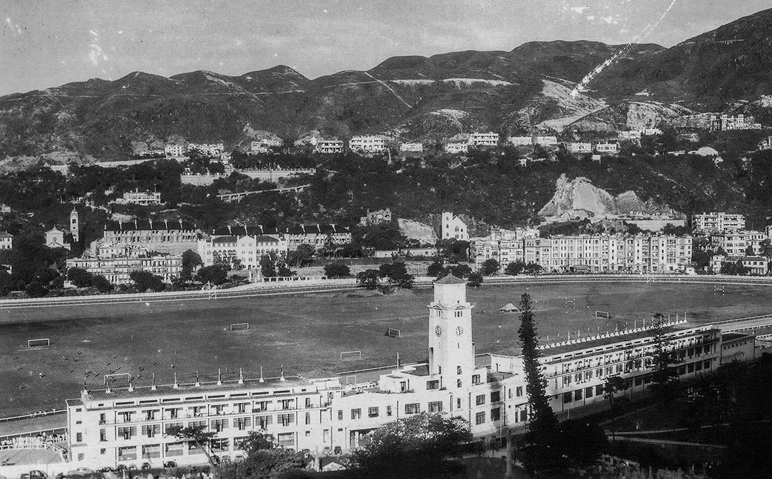 約1935年的跑馬地。左邊為樂活道的聖瑪加利大堂，其右則是位於黃泥涌道的聖保祿天主教小學。正中為剛落成的馬會新看台大樓。（圖片來源：鄭寶鴻提供）